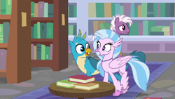 Size: 1280x720 | Tagged: safe, derpibooru import, screencap, gallus, silverstream, classical hippogriff, griffon, hippogriff, pony, a matter of principals, book, bookshelf, female, grin, jewelry, male, necklace, shipping fuel, smiling