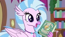 Size: 1920x1080 | Tagged: safe, derpibooru import, screencap, silverstream, hippogriff, the hearth's warming club, book, bookshelf, jewelry, necklace, open beak, solo, written equestrian