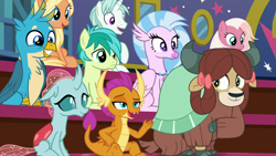 Size: 1280x720 | Tagged: safe, derpibooru import, screencap, gallus, ocellus, sandbar, silverstream, smolder, yona, changedling, changeling, classical hippogriff, dragon, earth pony, griffon, hippogriff, pony, unicorn, yak, a rockhoof and a hard place, beak, blanket, bow, chest fluff, claws, cloven hooves, dragoness, fangs, female, floppy ears, hair bow, hair ribbon, horn, jewelry, male, mare, monkey swings, necklace, open mouth, raised hoof, smiling, stallion, student six, teenager, wings