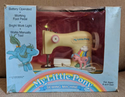 Size: 1017x786 | Tagged: safe, derpibooru import, firefly, medley, pegasus, pony, g1, box, female, irl, mare, merchandise, my little pony logo, open mouth, photo, rainbow, sewing machine, spread wings, standing, vintage, wings