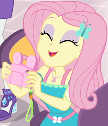 Size: 860x1004 | Tagged: safe, screencap, fluttershy, rarity, better together, equestria girls, holidays unwrapped, bunny ears, camera, canterlot mall, chair, clothes, cropped, cute, dashing through the mall, dress, eyes closed, female, flower, geode of fauna, gift giving, hairclip, happy, jewelry, magical geodes, mall, necklace, present, shyabetes, sitting, smiling, table, waistband