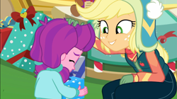 Size: 1922x1080 | Tagged: safe, screencap, applejack, lily longsocks, better together, equestria girls, holidays unwrapped, canterlot mall, child, clothes, cute, dawwww, duo, duo female, female, gift box, gift giving, hat, present, sweet dreams fuel, vest, wholesome, winter break-in, winter hat, winter outfit