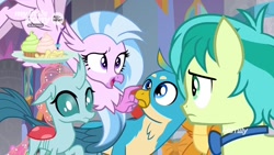 Size: 1280x720 | Tagged: safe, screencap, gallus, ocellus, sandbar, silverstream, smolder, changedling, changeling, classical hippogriff, dragon, griffon, hippogriff, pony, she's all yak, amused, bowtie, chips, claws, confused, cupcake, curved horn, flying, folded wings, food, frown, hands on hip, horn, looking up, male, pointing, raised eyebrow, spread wings, talons, teenager, tray, wings