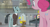 Size: 1366x738 | Tagged: safe, derpibooru import, screencap, pinkie pie, earth pony, pony, the last laugh, balcony, banana peel, bell jar, clothes, conveyor belt, factory, gag factory, glasses, hard hat, lights, sans smirk, suit, table, worker