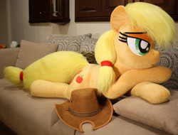 Size: 1024x778 | Tagged: safe, artist:ponimalion, applejack, earth pony, pony, bed, female, hat, lidded eyes, life size, mare, plushie, prone, sofa