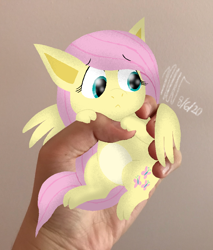 Size: 768x900 | Tagged: safe, artist:flutteryoshi952, derpibooru import, fluttershy, pegasus, pony, :<, colored belly, disembodied hand, female, hand, holding a pony, in goliath's palm, irl, looking away, looking down, mare, photo, ponies in real life, solo, spread wings, wings