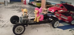 Size: 3264x1546 | Tagged: safe, derpibooru import, apple bloom, applejack, earth pony, pony, blind bag, chassis, chevrolet impala, engine, everfree customs, ford crown victoria police interceptor, garage, pontiac gto, toy, volkswagen beetle