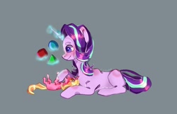 Size: 1030x664 | Tagged: safe, artist:lunar_cosmos, derpibooru import, luster dawn, starlight glimmer, pony, unicorn, blocks, duo, female, filly, foal, glowing horn, gray background, horn, levitation, luster dawn is starlight's and sunburst's daughter, lying down, magic, mama starlight, mare, mother and child, mother and daughter, parent and child, simple background, smiling, telekinesis