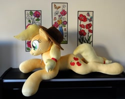 Size: 1140x904 | Tagged: safe, artist:purplenebulastudios, derpibooru import, applejack, earth pony, pony, applejack's hat, blonde, blonde mane, blonde tail, clothes, female, freckles, green eyes, hat, irl, life size, lying down, mare, orange coat, photo, plushie, prone, solo, table