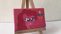 Size: 650x364 | Tagged: safe, alternate version, artist:lillycloudart, derpibooru import, pinkie pie, earth pony, pony, canvas, eyelashes, female, grin, irl, mare, photo, smiling, solo, toy, traditional art