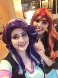 Size: 722x960 | Tagged: safe, artist:maddymoiselle, artist:sarahndipity cosplay, derpibooru import, starlight glimmer, sunset shimmer, human, beanie, clothes, cosplay, costume, duo, everfree northwest, everfree northwest 2019, hat, irl, irl human, looking at you, photo, smiling, smiling at you