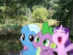 Size: 1032x774 | Tagged: safe, editor:undeadponysoldier, photographer:undeadponysoldier, spike, starlight glimmer, trixie, dragon, pony, unicorn, bush, cute, daaaaaaaaaaaw, diatrixes, dragons in real life, female, glimmerbetes, group hug, group photo, happy, male, mare, nature, open mouth, ponies in real life, river, side hug, smiling, spikabetes, spikelove, tree, wilderness, winged spike