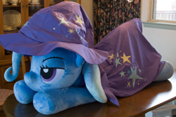 Size: 5184x3456 | Tagged: safe, artist:azgchip, derpibooru import, trixie, pony, unicorn, bedroom eyes, cape, clothes, female, hat, irl, life size, lying down, mare, photo, plushie, prone, solo, table, trixie's cape, trixie's hat