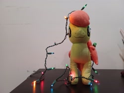 Size: 4000x3000 | Tagged: safe, artist:topsangtheman, derpibooru import, peachy sweet, earth pony, pony, apple family member, christmas, christmas lights, holiday, irl, looking at you, photo, plushie, solo