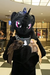Size: 600x900 | Tagged: safe, artist:atalonthedeer, derpibooru import, oc, oc:midnight romance, alicorn, anthro, bat, human, g4, 2016, bat plushie, convention, convention:eurofurence, fursuit, gem, horn, irl, irl human, jewelry, lidded eyes, looking at you, magenta eyes, photo, plushie, ponysuit, solo, tiara, why can't i hold all these x