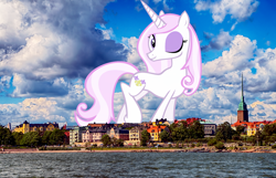 Size: 1920x1239 | Tagged: safe, artist:emu34b, artist:thegiantponyfan, derpibooru import, fleur-de-lis, pony, unicorn, female, finland, giant pony, giant unicorn, giantess, helsinki, highrise ponies, irl, looking at you, macro, mare, mega giant, one eye closed, photo, ponies in real life, raised leg, smiling, solo, wink