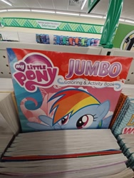 Size: 2448x3264 | Tagged: safe, derpibooru import, rainbow dash, pegasus, pony, coloring book, dollar tree, female, high res, irl, mare, my little pony jumbo coloring book, my little pony logo, open mouth, open smile, photo, raised hoof, raised leg, smiling, solo, spread wings, wings
