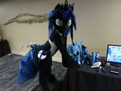 Size: 1758x1318 | Tagged: safe, artist:kolshica, derpibooru import, princess luna, alicorn, anthro, pony, bells, butt, clothes, crown, cutie mark, fursuit, glowing, glowing horn, hooves on the table, horn, irl, jewelry, leaning, leaning forward, looking at you, photo, plushie, ponysuit, regalia, solo, swimsuit, tail