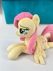 Size: 780x1040 | Tagged: safe, artist:kazzysplush, derpibooru import, fluttershy, pegasus, pony, eyelashes, female, for sale, irl, lidded eyes, lying down, mare, narrowed eyes, photo, plushie, prone, sitting, smiling, solo, sploot