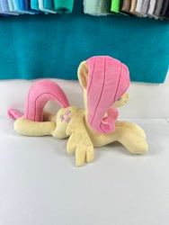 Size: 780x1040 | Tagged: safe, artist:kazzysplush, derpibooru import, fluttershy, pegasus, pony, eyelashes, female, for sale, hair over eyes, irl, lying down, mare, photo, plushie, prone, sitting, smiling, solo, sploot