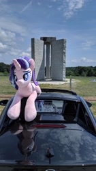 Size: 2160x3840 | Tagged: safe, derpibooru import, starlight glimmer, pony, unicorn, car, chain link fence, cloud, elbert county, female, fence, georgia (state), georgia guidestones, granite, grass, irl, lidded eyes, lying down, mare, monument, photo, plushie, prone, solo, tree