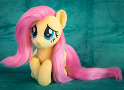 Size: 1984x1446 | Tagged: safe, artist:buttercupbabyppg, derpibooru import, fluttershy, pegasus, pony, female, folded wings, irl, lying down, mare, photo, plushie, prone, smiling, solo, wings