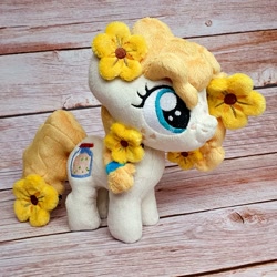Size: 1200x1200 | Tagged: safe, artist:straycatcrafts, derpibooru import, pear butter, earth pony, female, filly, flower, foal, hair tie, happy, irl, photo, plushie, smiling, solo, younger