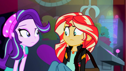 Size: 3072x1727 | Tagged: safe, derpibooru import, screencap, starlight glimmer, sunset shimmer, human, equestria girls, mirror magic, spoiler:eqg specials, beanie, canterlot mall, cinema, clothes, duo, duo female, female, frown, geode of empathy, hat, jacket, jewelry, leather, leather jacket, looking at each other, looking at someone, magical geodes, necklace