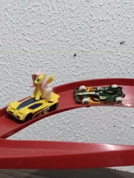 Size: 2448x3264 | Tagged: safe, artist:tom artista, derpibooru import, fluttershy, pegasus, pony, g4, car, crossover, female, formula 1, hot wheels, indoors, kinder egg, pilot, race, race track, racecar, racing, side draft, toy, tracks, vehicle