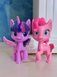 Size: 3058x4078 | Tagged: safe, derpibooru import, pinkie pie, twilight sparkle, twilight sparkle (alicorn), alicorn, g4, g4.5, my little pony: pony life, cracking, figure, front view, irl, kinder egg, looking at someone, merchandise, official, open mouth, photo, raised hoof, raised leg, spread wings, toy, wings