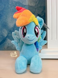 Size: 2694x3592 | Tagged: safe, derpibooru import, rainbow dash, pegasus, pony, g4, front view, irl, looking at you, lying down, merchandise, official, photo, plushie, pony plushie, reesee, smiling, solo, spread wings, wings