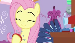 Size: 1920x1088 | Tagged: safe, derpibooru import, screencap, fluttershy, pegasus, dragon dropped, g4, season 9, carousel boutique, cute, eyebrows, happy, holding, pink hair, pink mane, room, sewing machine, shyabetes, sitting, smiling, solo, yellow fur