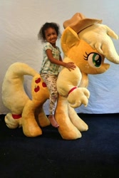 Size: 533x800 | Tagged: safe, artist:karasunezumi, derpibooru import, applejack, earth pony, human, pony, g4, barely pony related, child, curly hair, female, freckles, happy, hat, humans riding ponies, irl, looking at you, photo, pinterest, plushie, riding, riding a pony, rubber band, sitting, smiling, smiling at you, soft toy, solo, standing, unnamed human