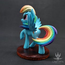 Size: 2560x2560 | Tagged: safe, alternate version, artist:lakterra, derpibooru import, rainbow dash, pegasus, pony, g4, alternate angle, butt, craft, female, figurine, irl, looking up, mare, photo, plot, polymer clay, raised hoof, raised leg, signature, smiling, solo, spread wings, stand, tail, three quarter view, wings