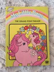 Size: 810x1080 | Tagged: safe, derpibooru import, baby cotton candy, cotton candy (g1), earth pony, pony, g1, book, book cover, bow, cover, duo, duo female, female, filly, flower, foal, mare, official, tail, tail bow, the grand pony parade