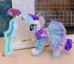 Size: 1500x1298 | Tagged: safe, derpibooru import, rarity, original species, pony, unicorn, aura, clothes, dress, flower, glowing, glowing horn, hooves, horn, jewelry, magic, magic aura, necklace, outfit, photo, plushie, pony plushie, princess rarity, raised hoof, raised leg, solo