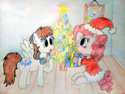 Size: 4032x3016 | Tagged: safe, artist:jakusi, derpibooru import, pinkie pie, oc, earth pony, pegasus, pony, g4, canterlot, christmas, christmas tree, clothes, costume, duo, duo female, female, gift giving, happy, hat, headphones, holiday, mare, pegasus oc, picture frame, present, santa costume, santa hat, sitting, traditional art, tree, wings