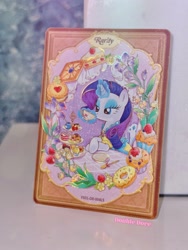 Size: 2206x2941 | Tagged: safe, derpibooru import, rarity, pony, unicorn, g4, afternoon tea, cake, card, clothes, cup, dessert, double dove, dress, flower, food, horn, irl, kayou, looking down, magic, magic aura, merchandise, official, outfit, photo, plate, solo, teacup, text